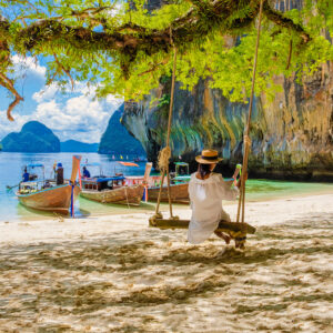 women on a swing at the Tropical lagoon of Koh Loa Lading Krabi Thailand part of Koh Hong Islands